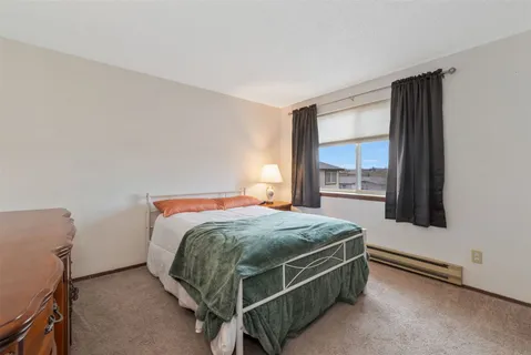 a bed sitting in a bedroom next to a window