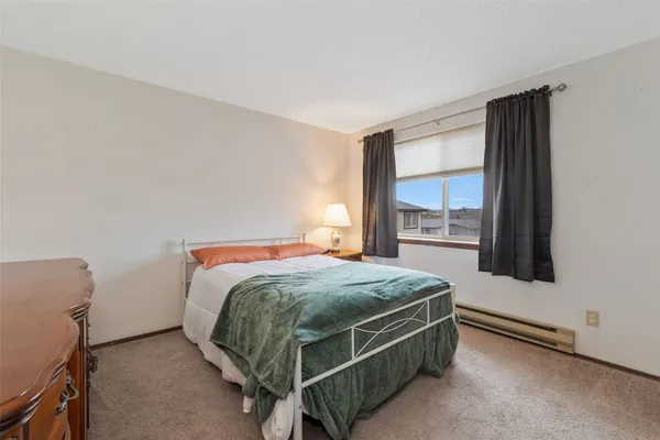 a bed sitting in a bedroom next to a window