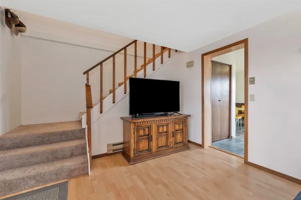 a view of a livingroom with wooden floor and furniture