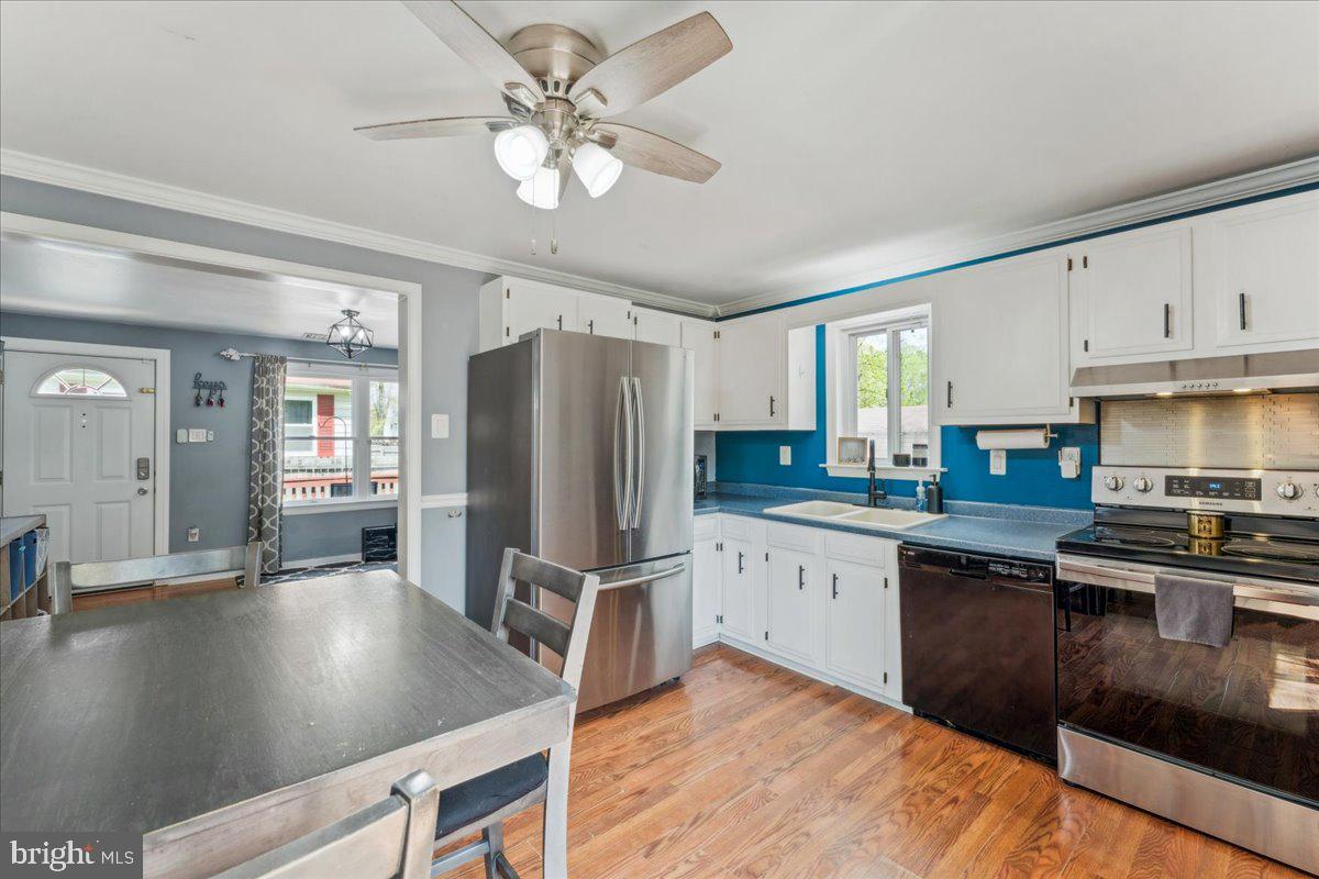 5519 Baskin Street Churchton, MD 20733 - Photo 5 of 20 a kitchen with stainless steel appliances granite countertop a refrigerator a sink dishwasher a stove and white countertops with wooden floor