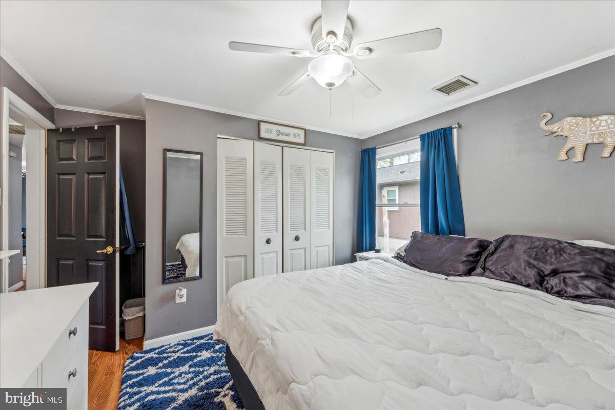 5519 Baskin Street Churchton, MD 20733 - Photo 9 of 20 a bedroom with a large bed and a chandelier