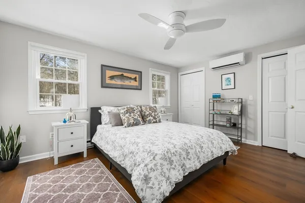 a bedroom with a bed and a table in it with wooden floor