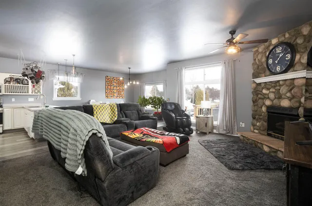 a living room with furniture a large window and a fireplace