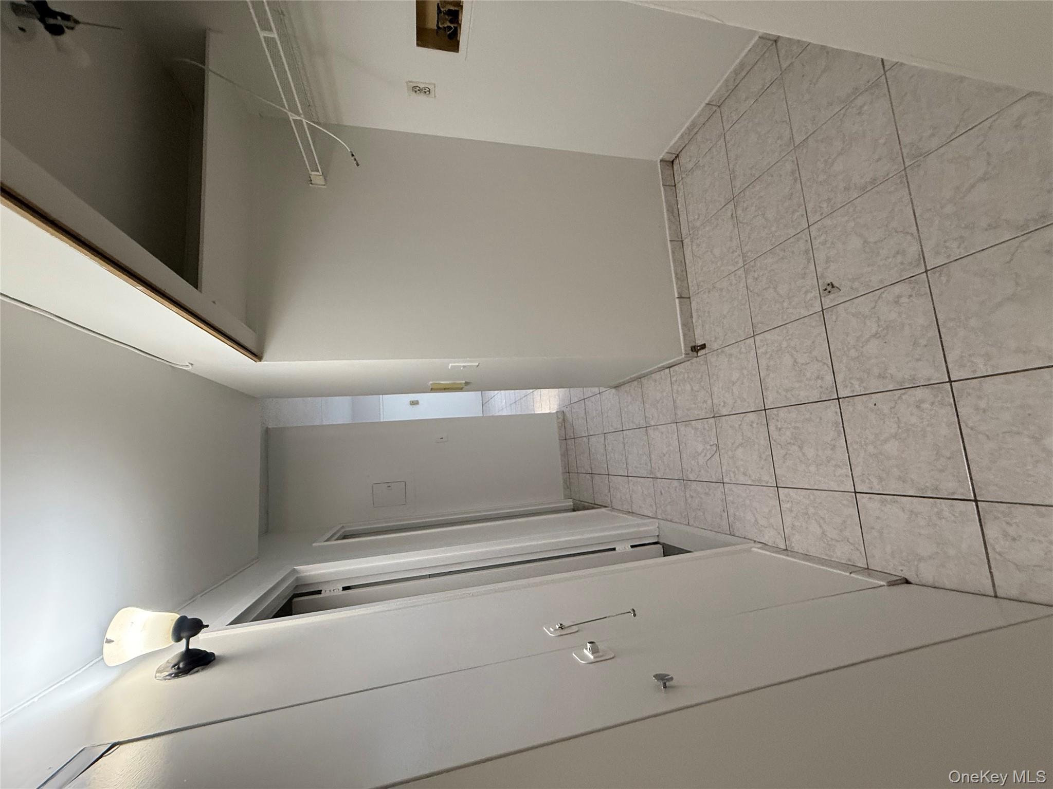 769 St Ann's Avenue, Unit B Bronx, NY 10456 - Photo 36 of 48 a view of a livingroom with white floor and cabinets