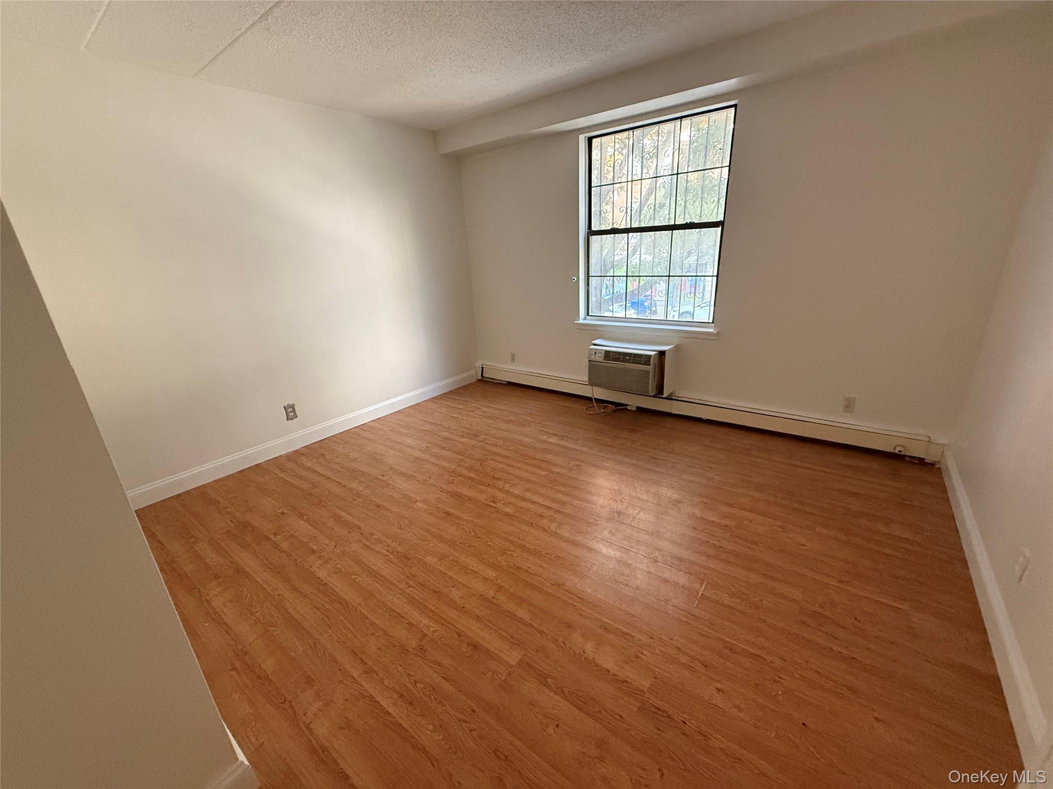 769 St Ann's Avenue, Unit B Bronx, NY 10456 - Photo 37 of 48 an empty room with wooden floor and windows