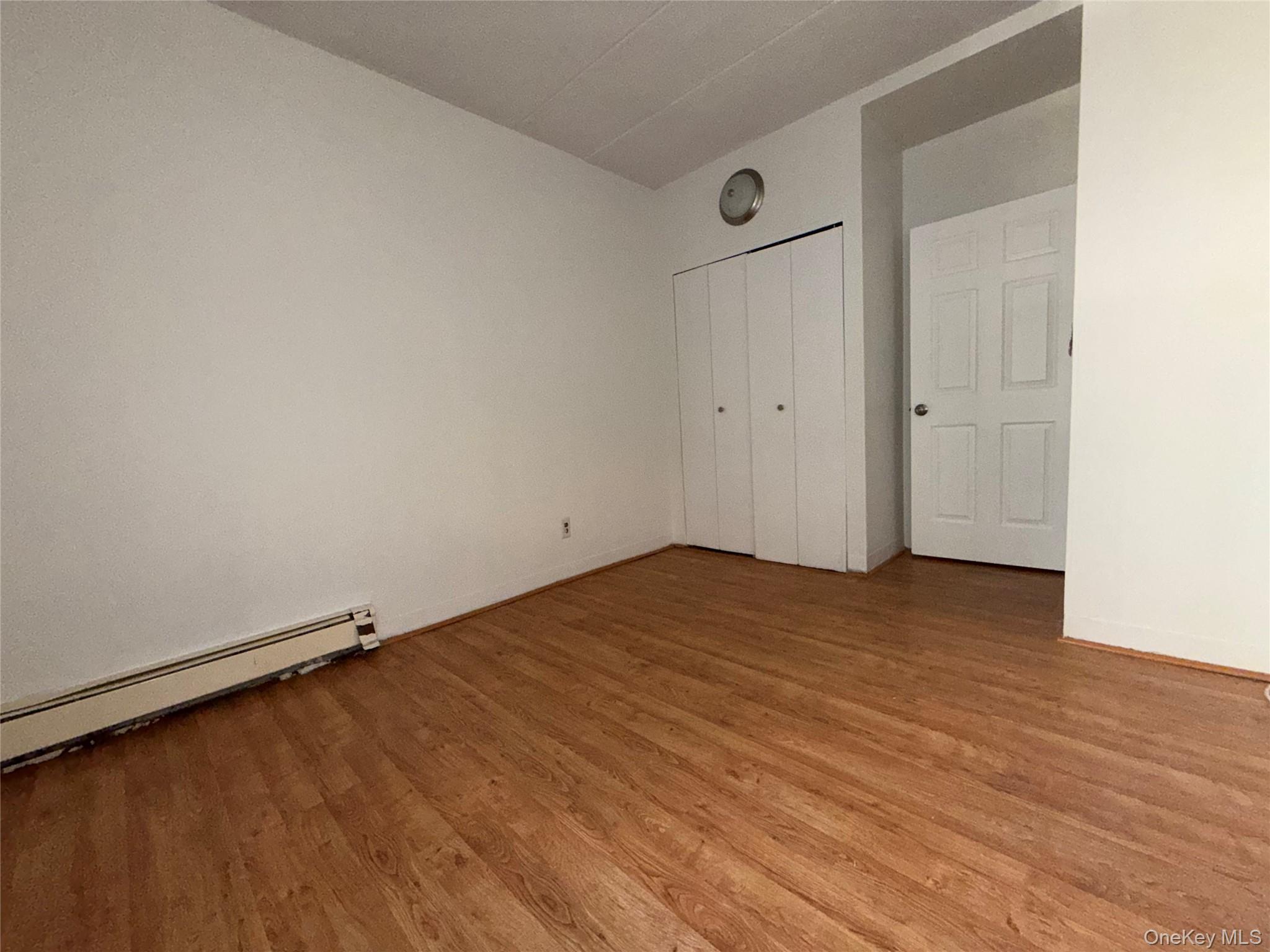 769 St Ann's Avenue, Unit B Bronx, NY 10456 - Photo 42 of 48 an empty room with wooden floor and windows