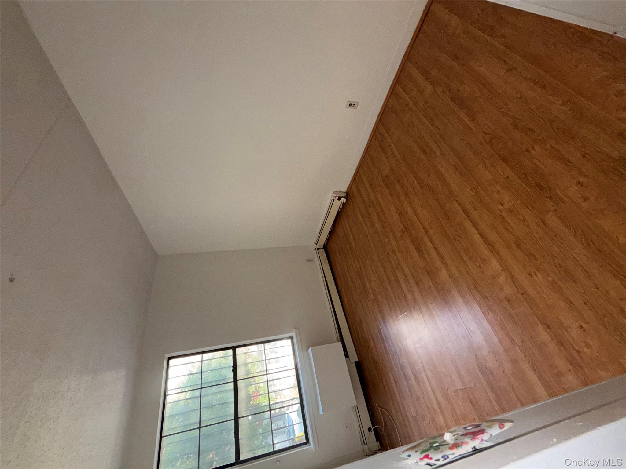 769 St Ann's Avenue, Unit B Bronx, NY 10456 - Photo 43 of 48 an empty room with wooden floor and windows
