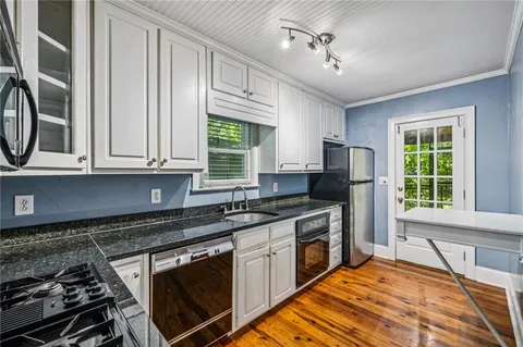 a kitchen with stainless steel appliances granite countertop a stove a sink and a microwave