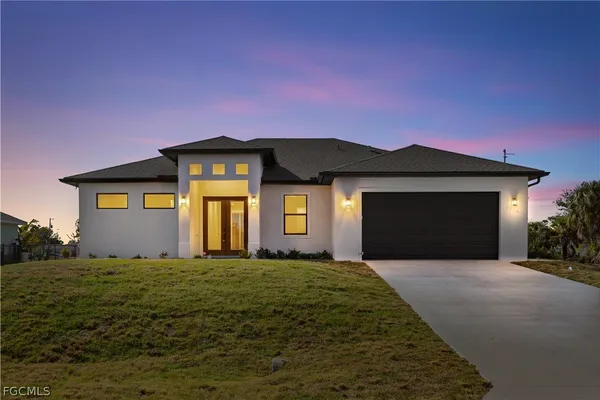 a front view of a house with yard and trees
