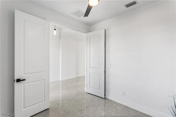 an empty room with a window and a ceiling fan