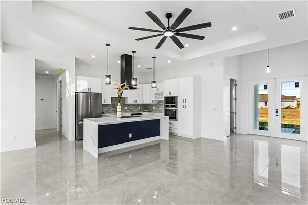 a large kitchen with stainless steel appliances kitchen island granite countertop a refrigerator and a stove top oven