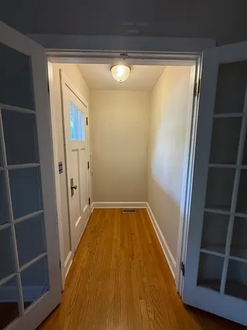 a view of empty room with wooden floor