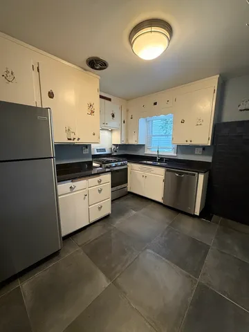 a kitchen with stainless steel appliances granite countertop a stove a sink and a refrigerator