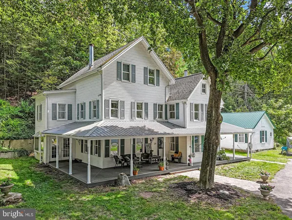 a front view of a house with a yard and trees