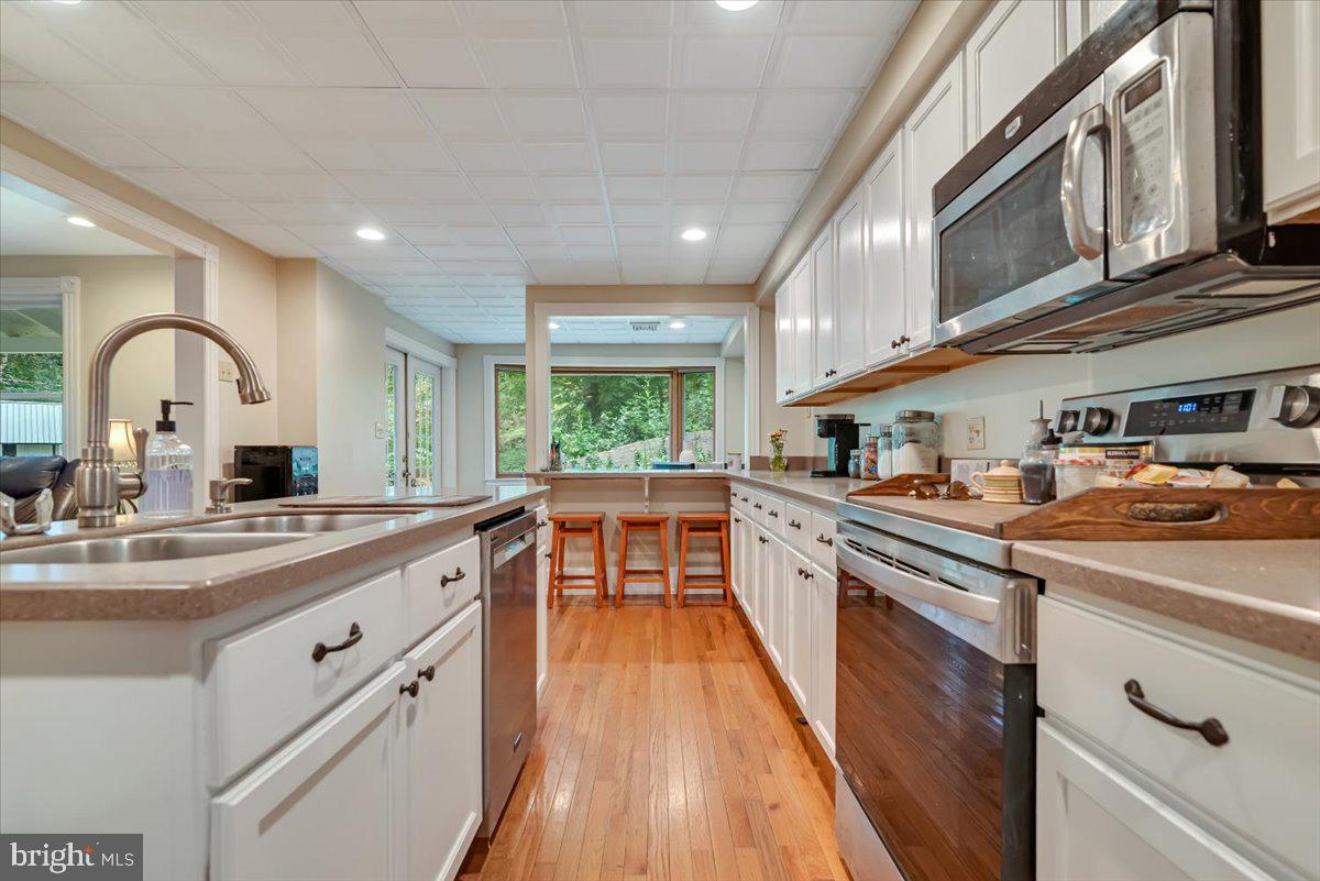3585 Fairyland Road Lehighton, PA 18235 - Photo 17 of 109 a kitchen with kitchen island granite countertop a sink a counter space appliances and cabinets