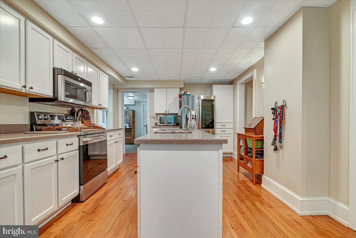 3585 Fairyland Road Lehighton, PA 18235 - Photo 20 of 109 a kitchen with stainless steel appliances granite countertop a refrigerator a sink dishwasher a stove and white cabinets with wooden floor