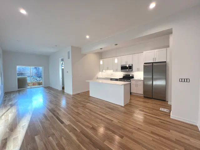a view of kitchen with wooden floor electronic appliances and window