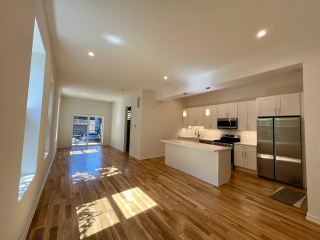 a kitchen with stainless steel appliances a sink a stove a refrigerator and cabinets
