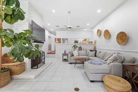 a living room with patio furniture and a potted plant