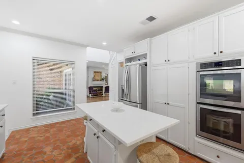 a kitchen with granite countertop a stove refrigerator and microwave