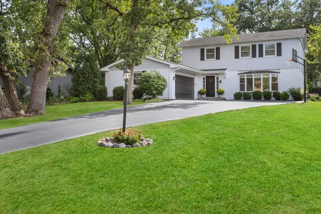 a front view of a house with a yard and tree