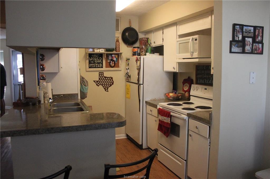 4441 Old College Road, Unit 3104 Bryan, TX 77801 - Photo 3 of 6 a kitchen with stainless steel appliances granite countertop a stove and a refrigerator
