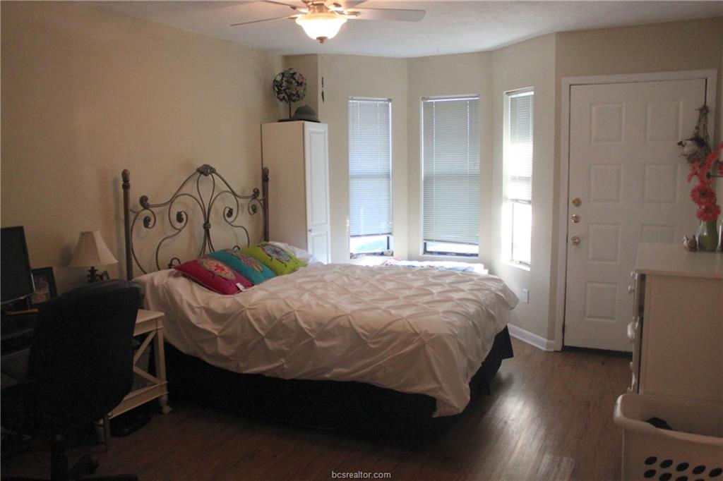 4441 Old College Road, Unit 3104 Bryan, TX 77801 - Photo 4 of 6 a bed sitting in a bedroom next to a window and a chair