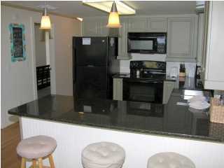 6050 Hwy Santa Rosa Beach, Unit 30A Santa Rosa Beach, FL 32459 - Photo 8 of 23 a kitchen with stainless steel appliances kitchen island a refrigerator and a stove top oven