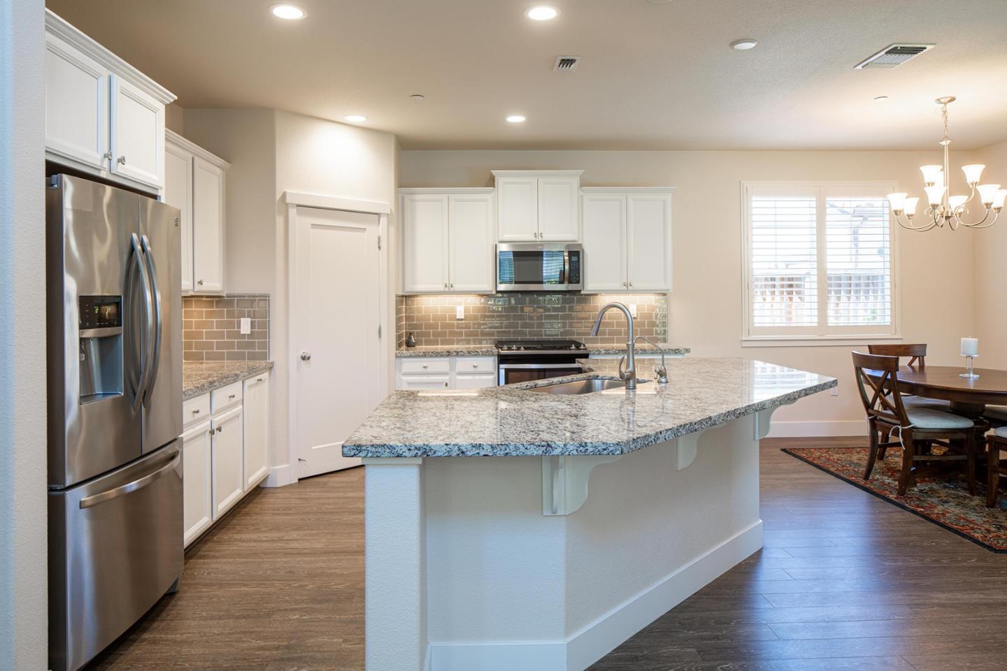 14741 Kit Carson Drive East Garrison, CA 93933 - Photo 8 of 24 a kitchen with stainless steel appliances granite countertop a refrigerator a stove a sink a dining table and chairs