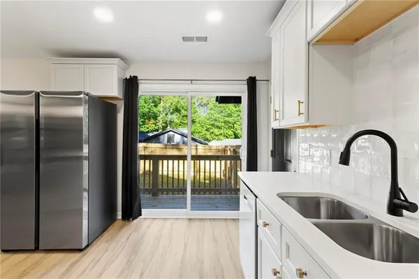 a kitchen with a refrigerator sink and cabinets