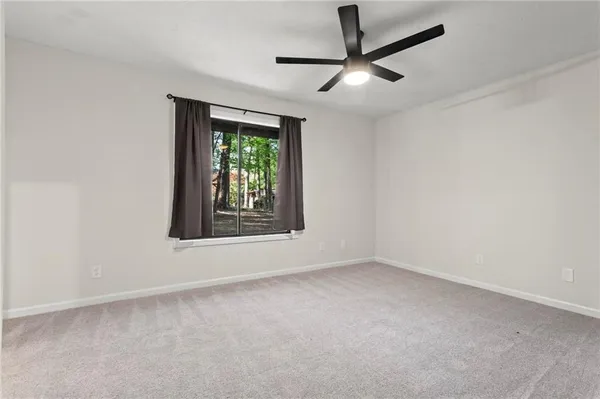 an empty room with a window and a fan