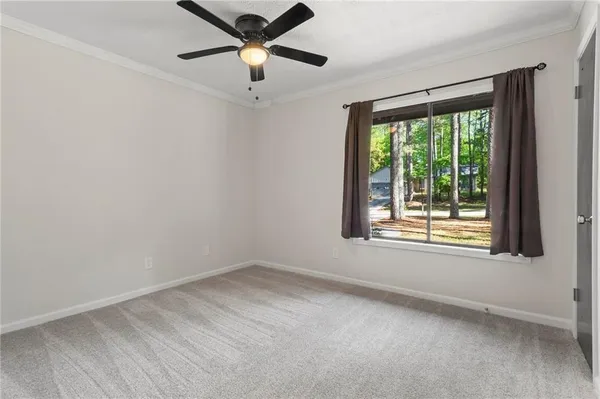 an empty room with a window and a ceiling fan