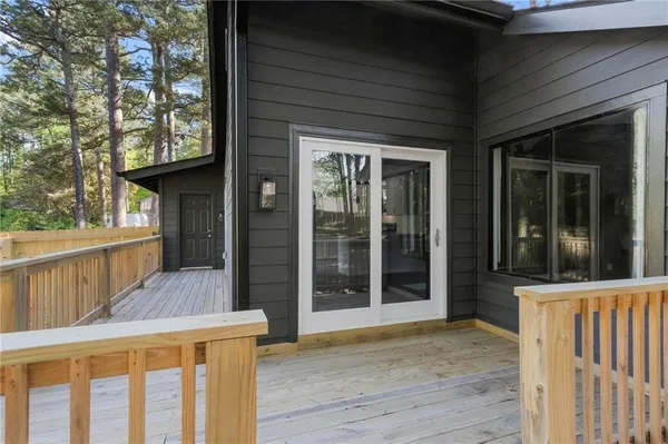 a view of a deck with wooden floor and a yard with wooden fence