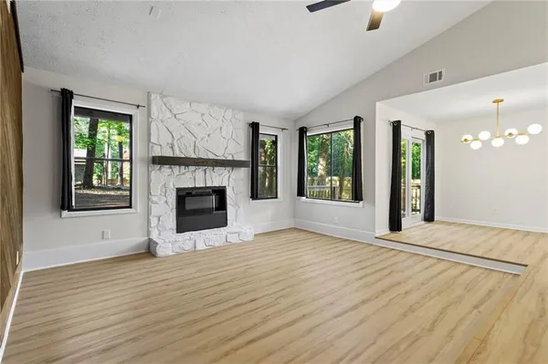 a view of an empty room with window and fire place