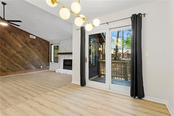 a view of a hallway with wooden floor and chandelier