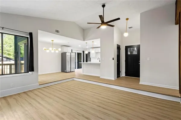 a view of an empty room with wooden floor and a window