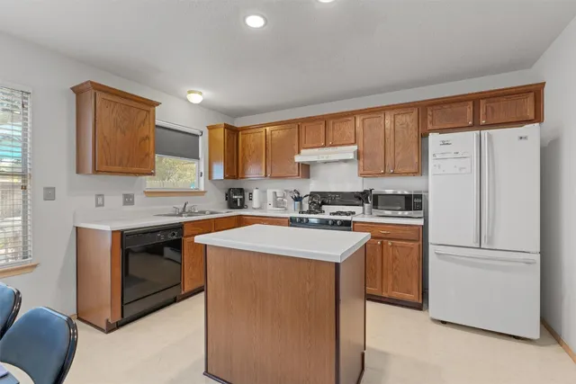 a kitchen with stainless steel appliances granite countertop a refrigerator a stove a sink dishwasher and a refrigerator