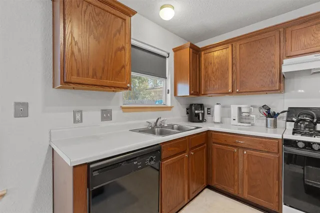 a kitchen with stainless steel appliances granite countertop a sink stove and cabinets