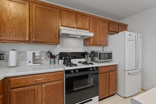 a kitchen with stainless steel appliances granite countertop a refrigerator stove and sink with cabinets