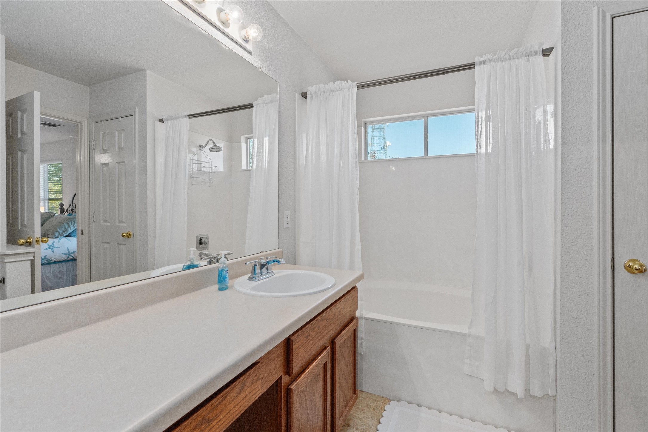 15419 Craig's Crest Path Pflugerville, TX 78660 - Photo 26 of 36 a bathroom with a granite countertop sink a mirror and a bathtub