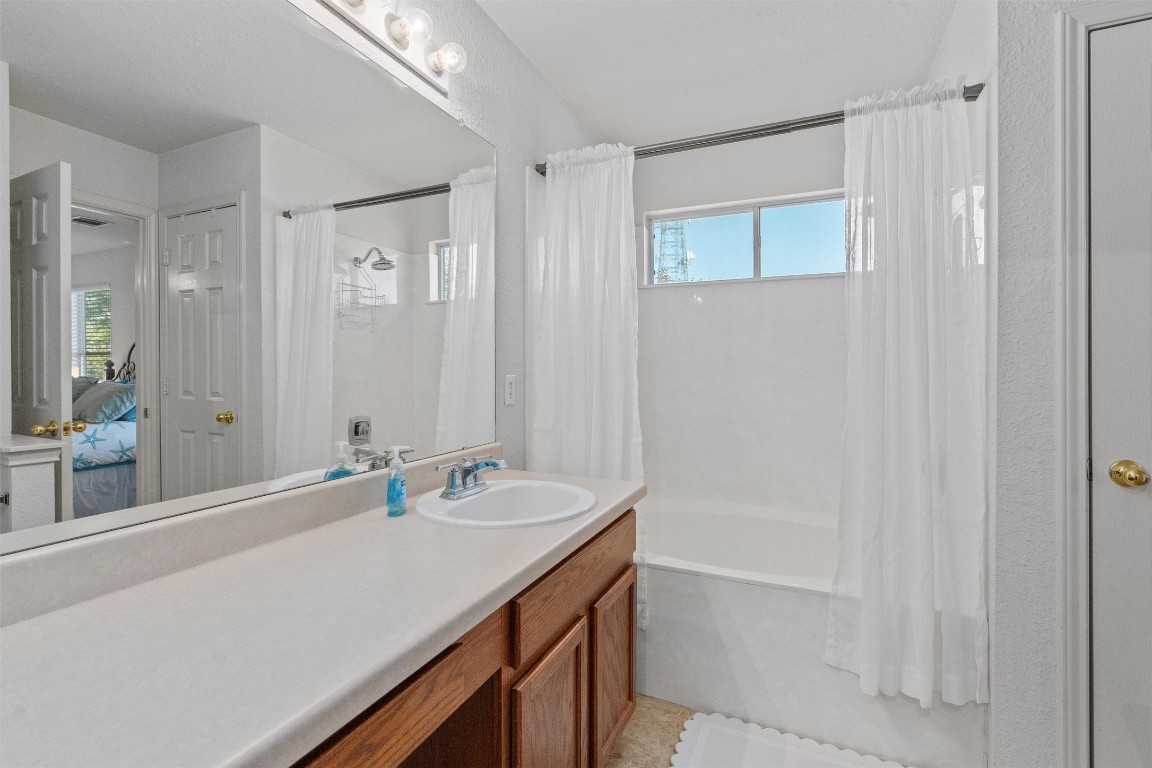 15419 Craig's Crest Path Pflugerville, TX 78660 - Photo 26 of 36 a bathroom with a sink a shower and a mirror
