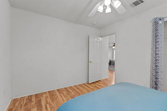 a bedroom with a bed and a chandelier fan