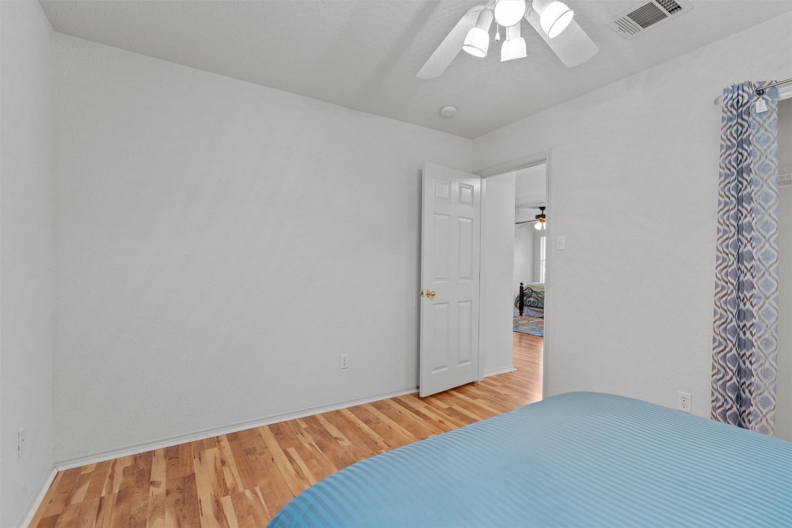 15419 Craig's Crest Path Pflugerville, TX 78660 - Photo 28 of 36 a bedroom with a bed and a chandelier fan