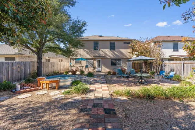 a view of a house with backyard water fountain and sitting area
