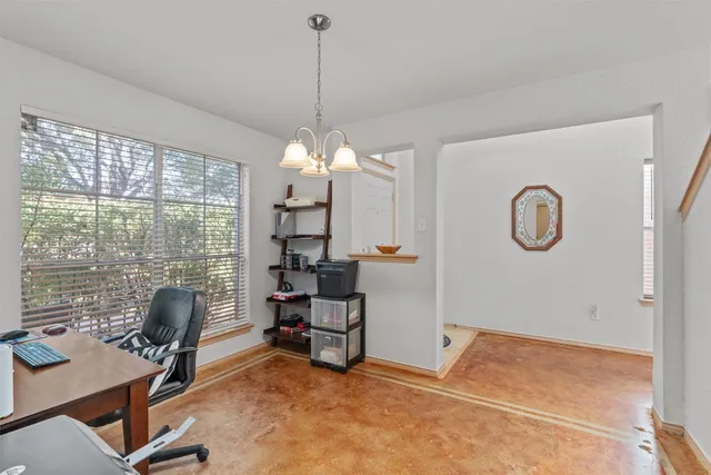 a view of a workspace with furniture and a window