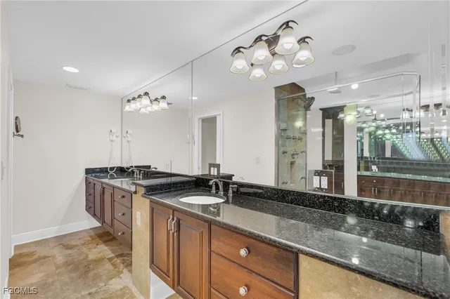 a bathroom with a granite countertop double vanity sink and a mirror