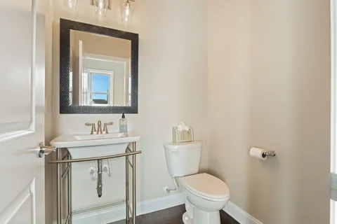 a bathroom with a toilet a sink and mirror