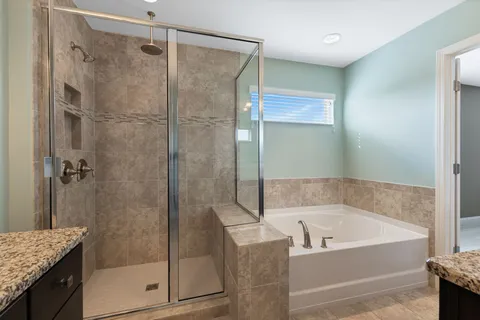 a bathroom with a granite countertop bathtub shower and sink