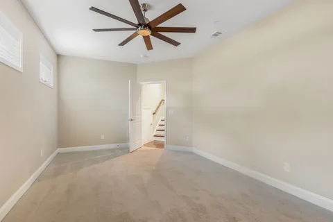 an empty room with a ceiling fan and a window