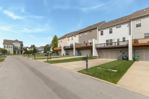 a view of a white house with a swimming pool and wooden fence